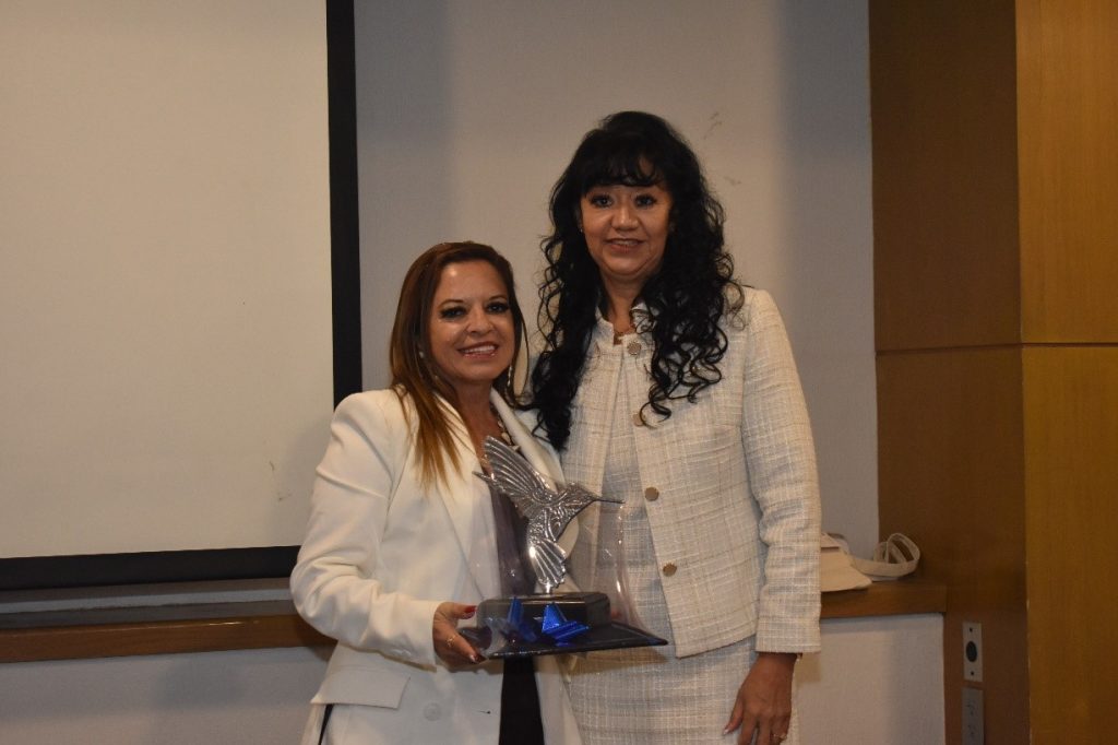 Teresa Hernández entrego un reconocimiento a Adriana Martínez por el patrocinio de la comida de fin de año de CONFETUR.